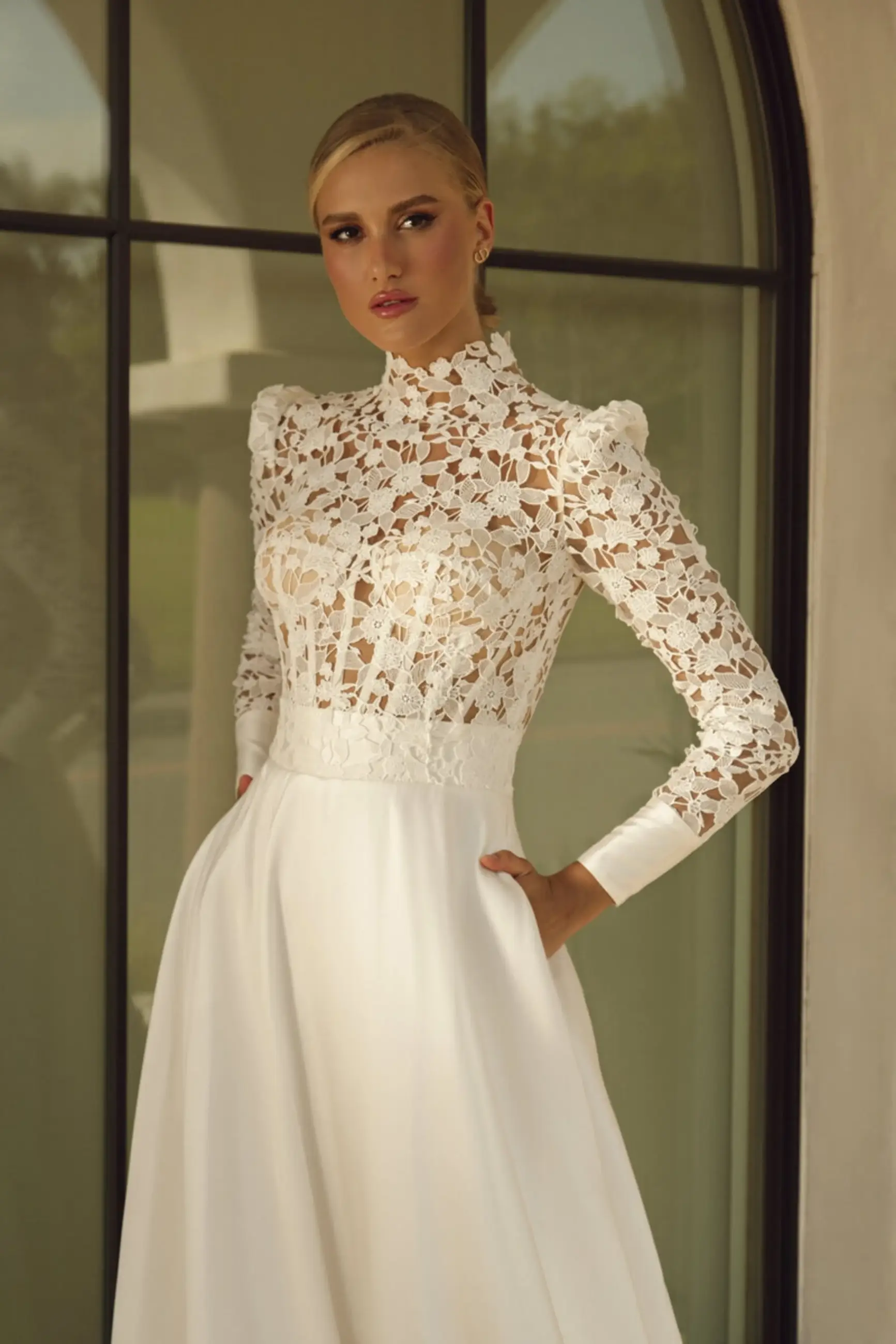 model is wearing a high neckline long sleeve ball gown wedding dress 