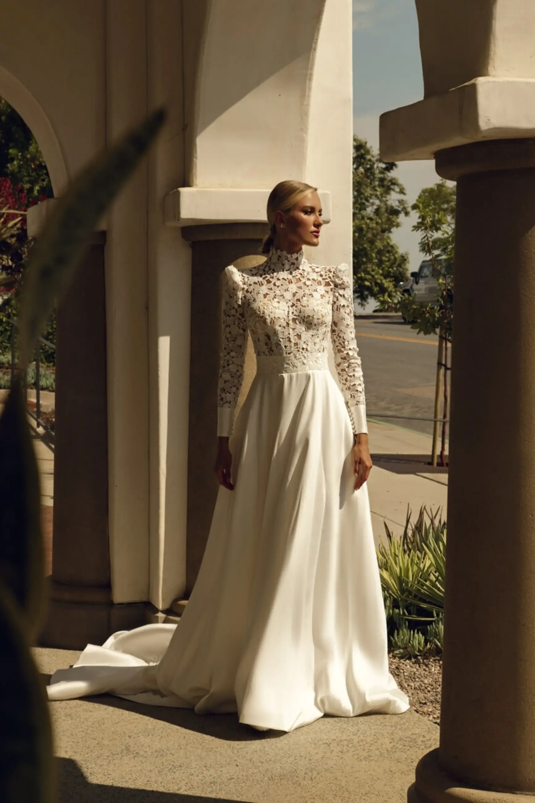model is wearing a high neckline long sleeve ball gown wedding dress 