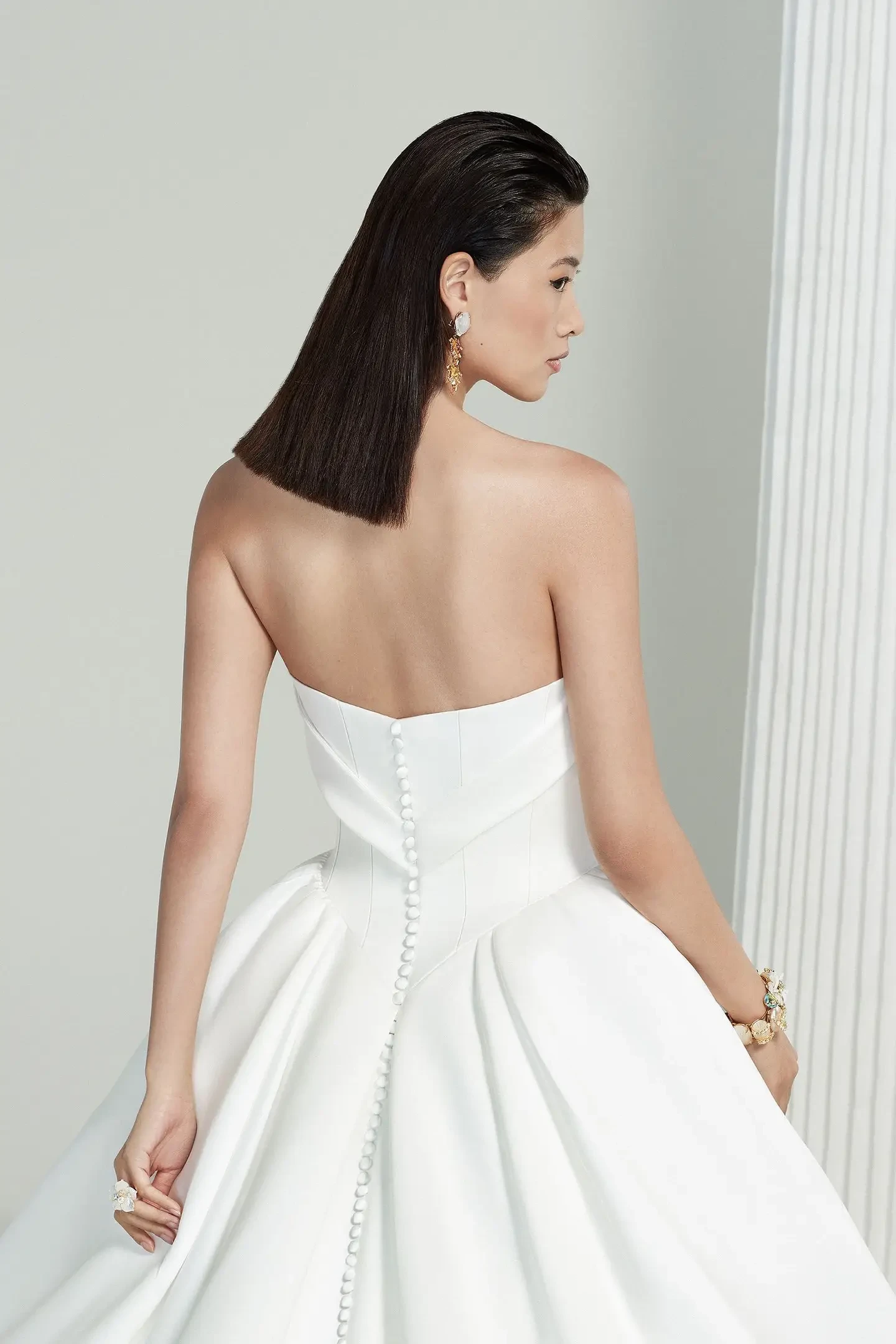 model is wearing a strapless ball gown wedding dress