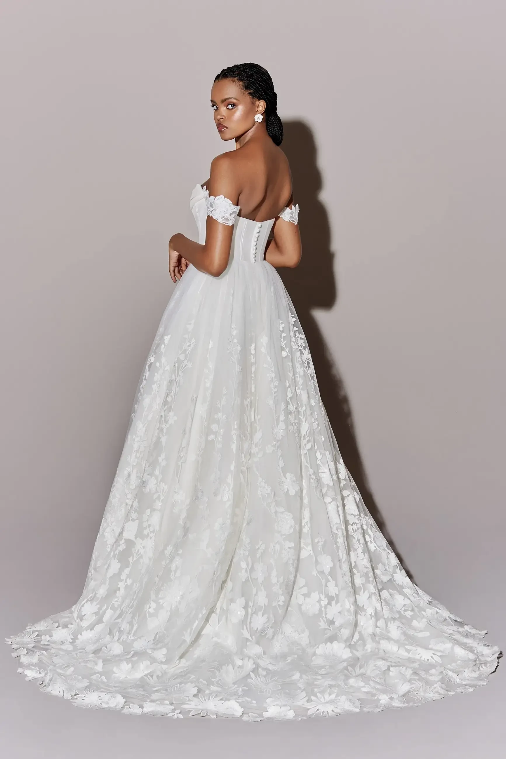 model is wearing an off the shoulder lace a-line bridal gown