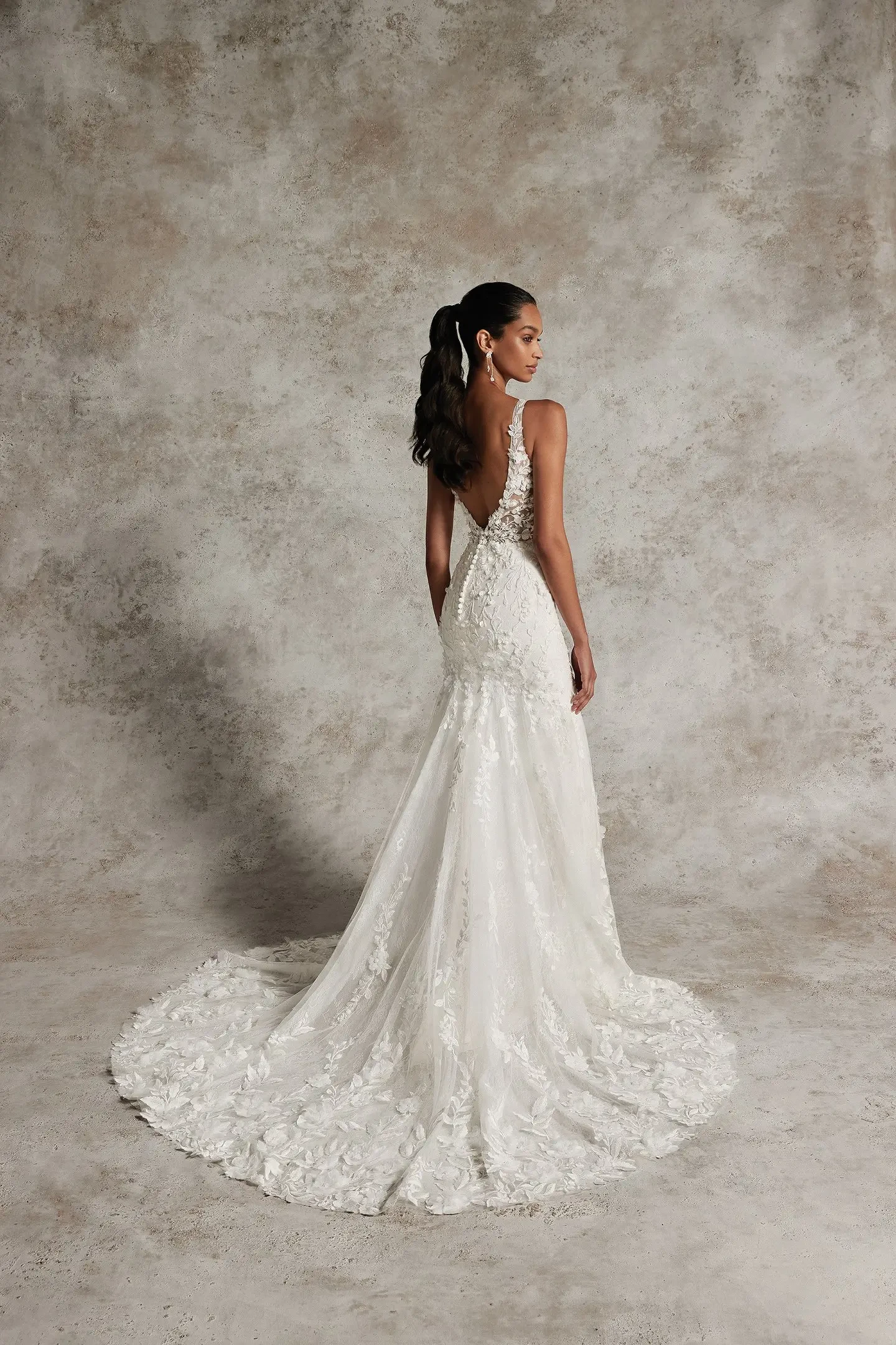 model is wearing a sleeveless high open back wedding dress