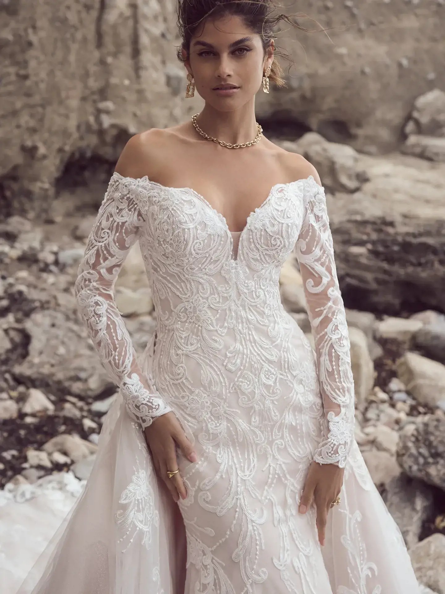 Model wearing a white long sleeved bridal gown