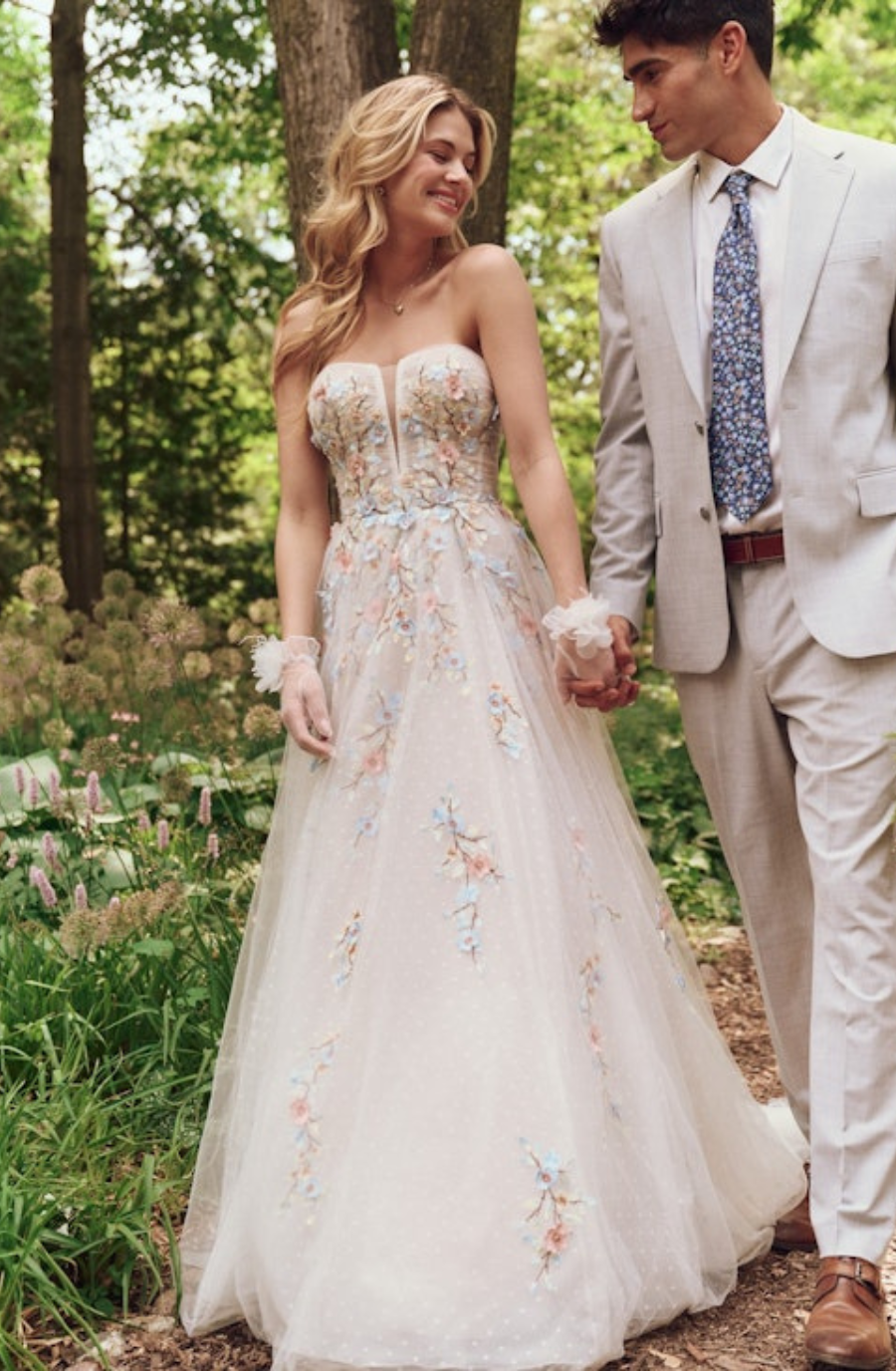 Model is wearing a strapless a-line floral lace wedding dress