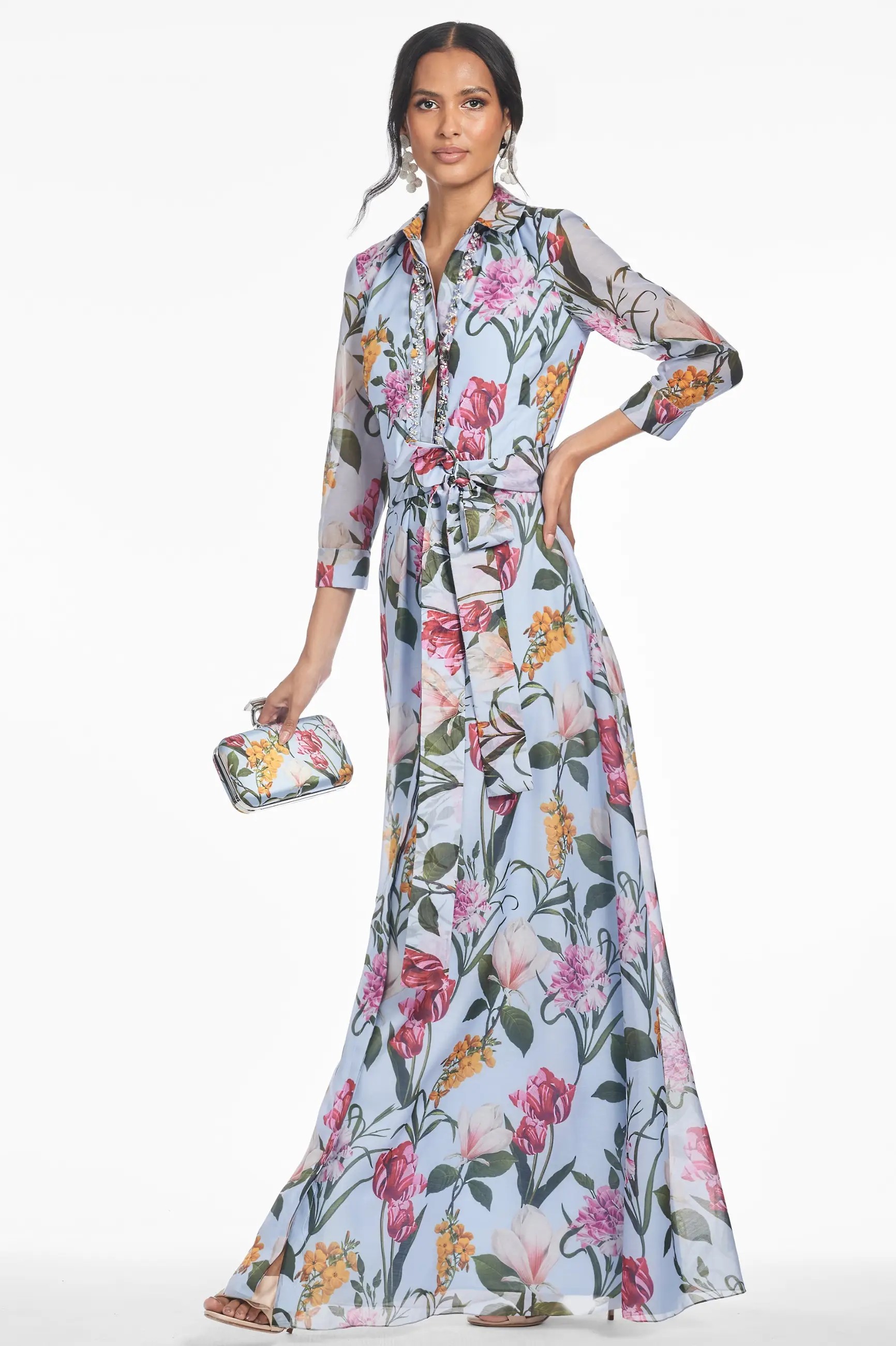 Model is wearing a floor length three-quarter sleeve floral gown