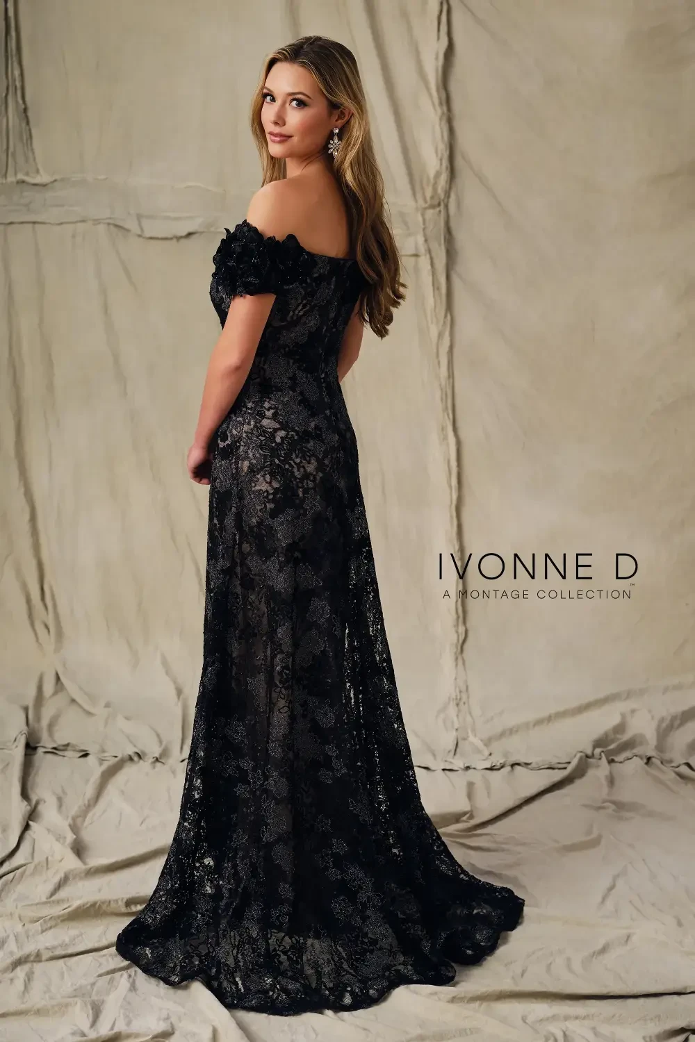 A woman wearing a black lace evening gown with floral details, standing against a neutral backdrop, with the text 