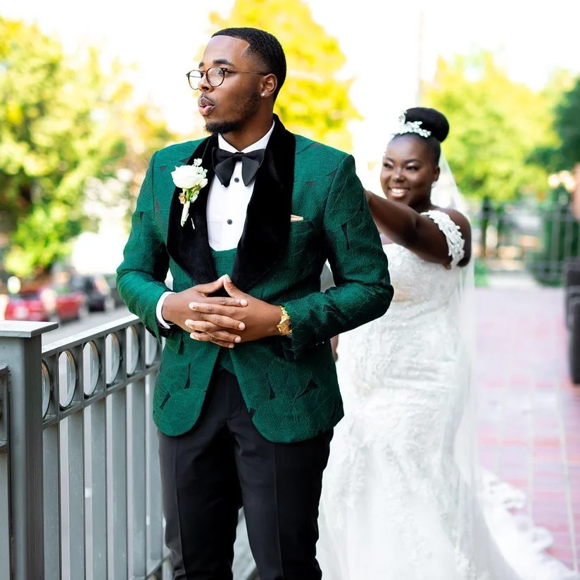 image shows a male model wearing a green tux and a woman wearing a wedding dress