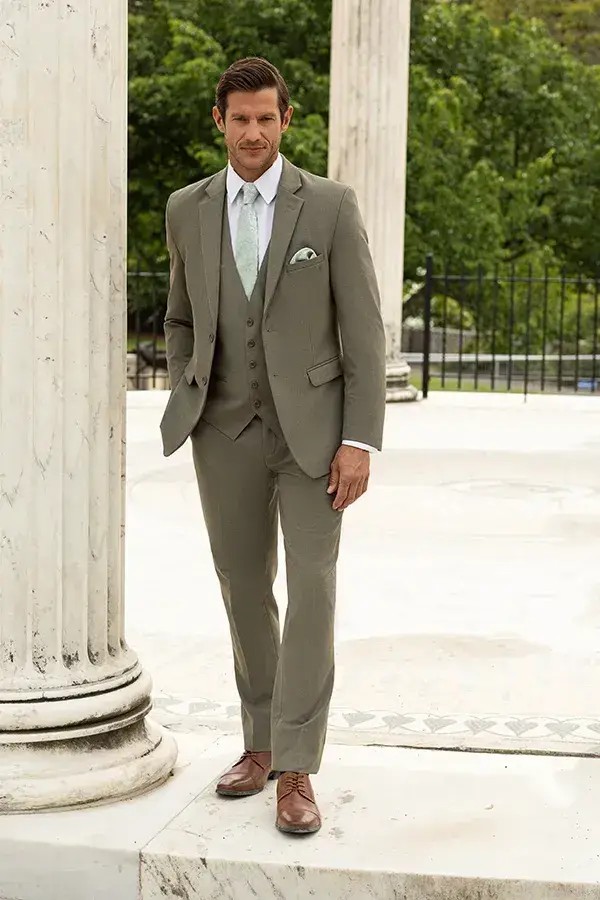 Model is wearing a sage two-piece suit with stretch fabric