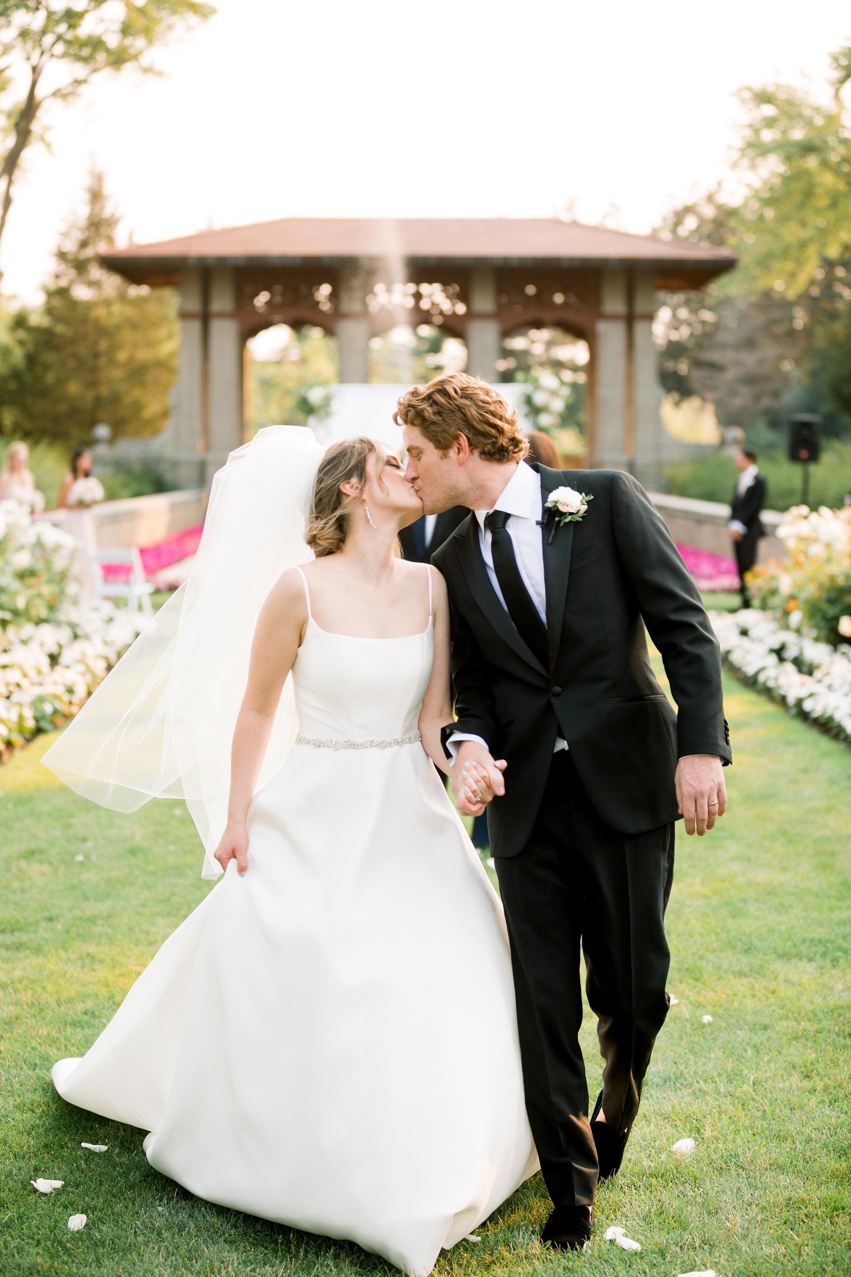 Сouple wearing a white gown and a black suit on the grass