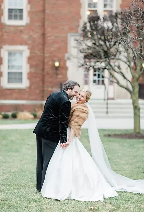 Сouple wearing a white gown and a black suit on the grass